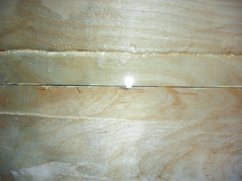 A second, thicker coat of epoxy covering the fiberglass cloth